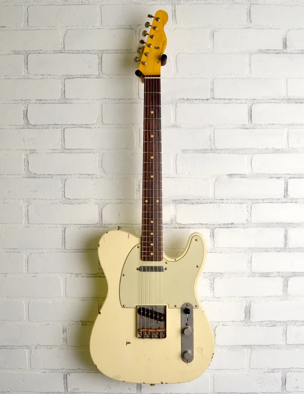 Nash T-63 Olympic White Telecaster-style guitar against a brick wall