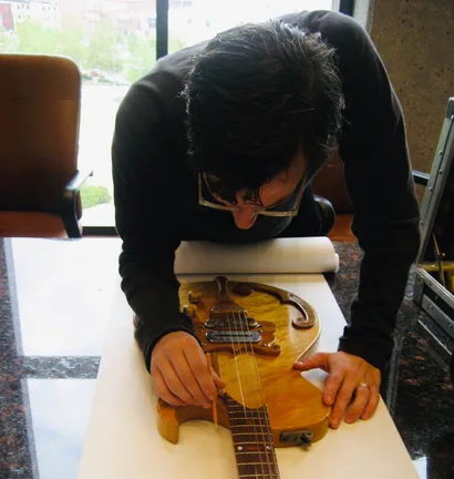 John Woodland examining a vintage guitar