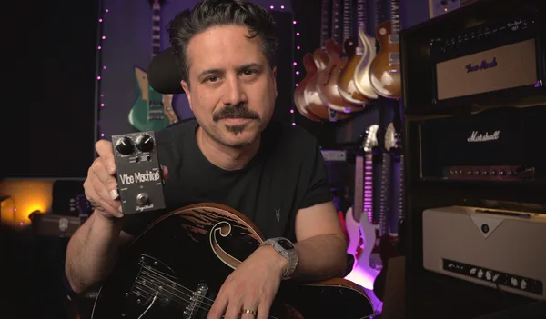 Corey Congilio holding a DryBell Vibe Machine pedal