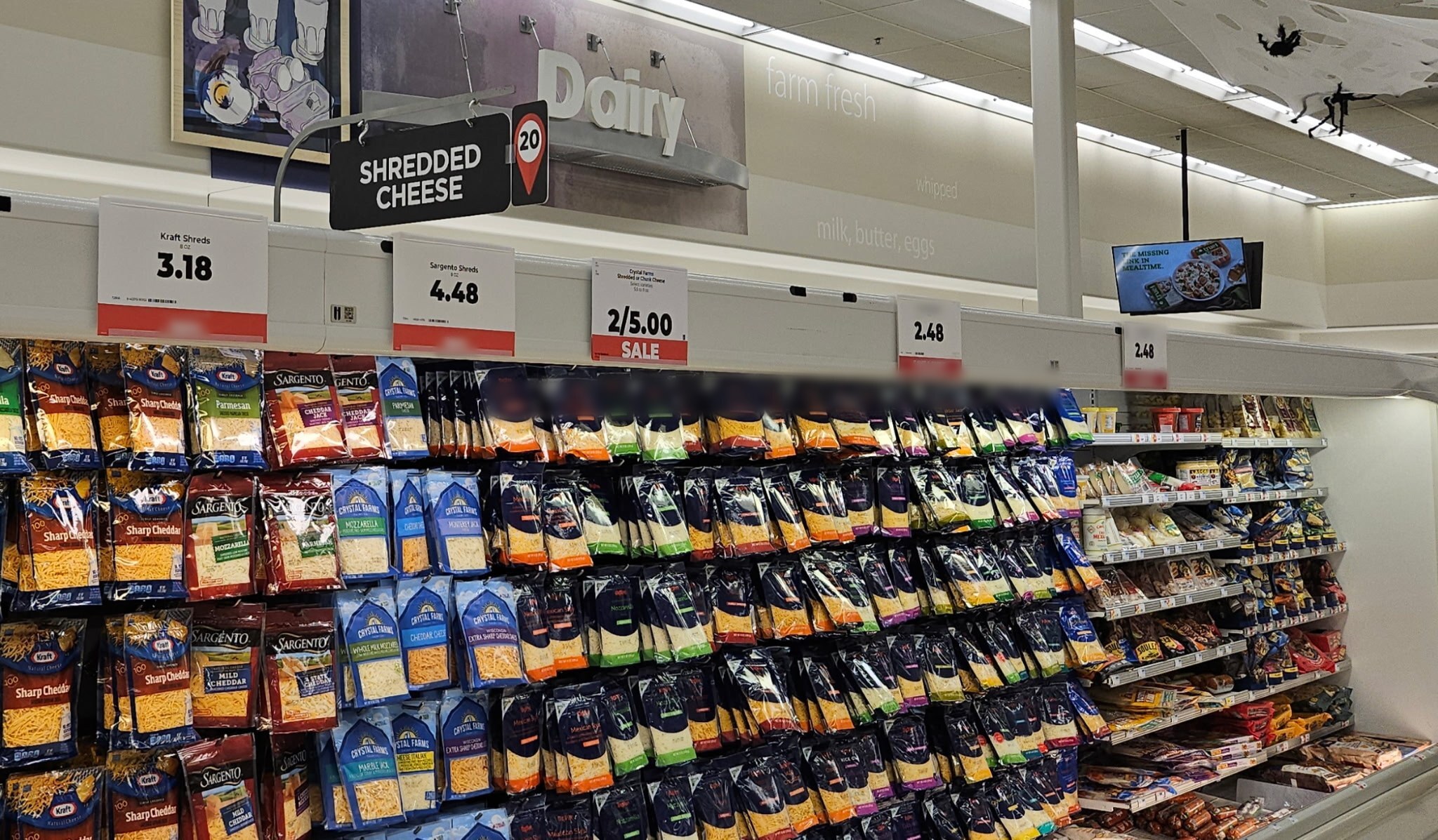 Canopy brackets holding price signs along a dairy case