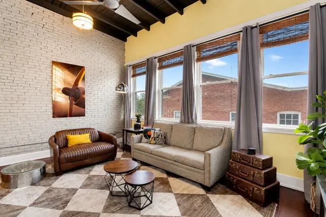 Wings Over Nulu | Luxury Industrial Loft Downtown Louisville: Living room with leather sofa and checkered floor