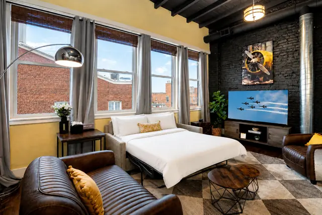 Wings Over Nulu | Luxury Industrial Loft Downtown Louisville: Living room and bed