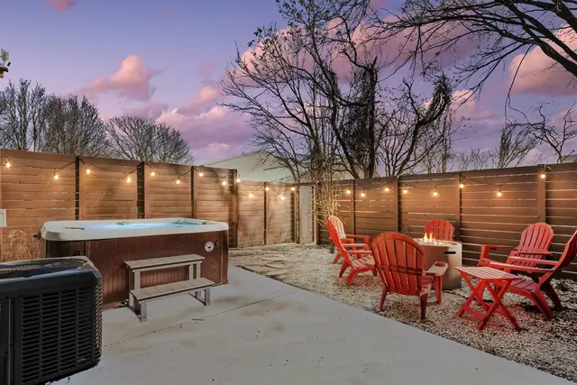 Prime NULU Escape: Sleek 4BR w/ Hot Tub & Style: Backyard with hot tub at dusk