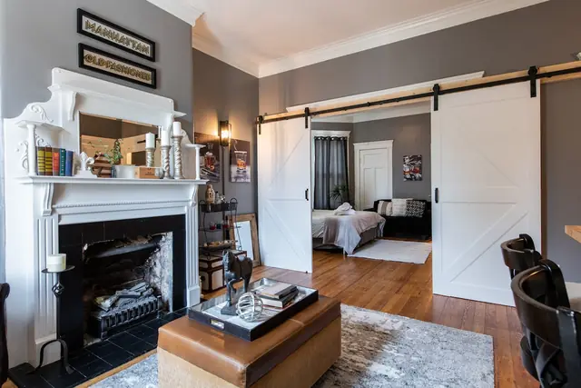 The Paddock Guesthouse | 9BR Highlands Home on Restaurant Row, Louisville: Living room fireplace and barn door