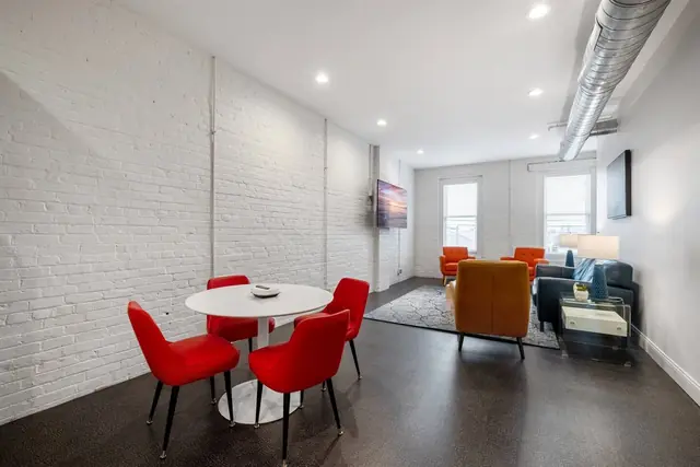 The Lily: Dining table with red chairs and living room