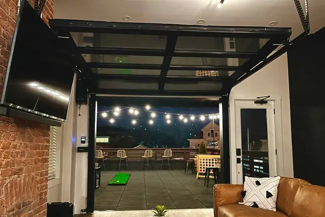 Rooftop Stay: Glass garage door lounge opening to the rooftop