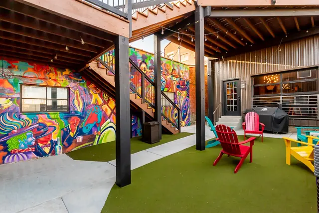 The Ultimate Louisville Event Estate | 12BR Double Property: Courtyard with colorful mural and Adirondack chairs