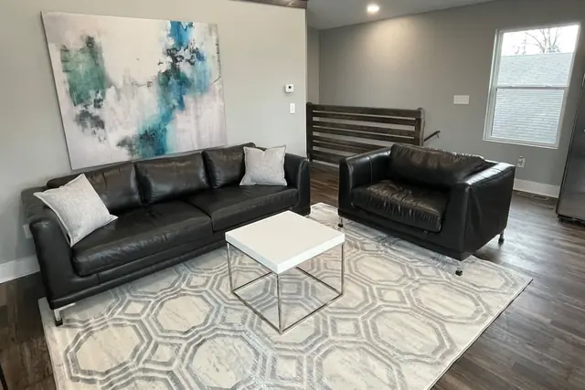Triple Crown Retreat: Living room with black leather sofa