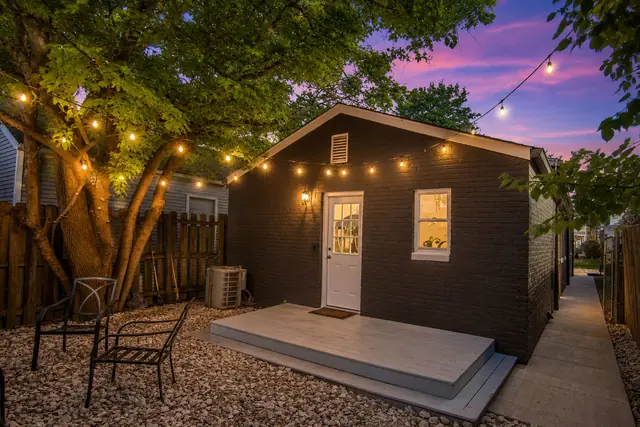 The Julep House NuLu: Backyard cottage at dusk with string lights