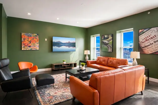 Nulu Marketplace Double Play: Vacation Rentals Louisville KY: Living room with green walls and orange sofas