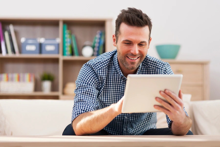 Young man using tablet to determine his monthly car payments
