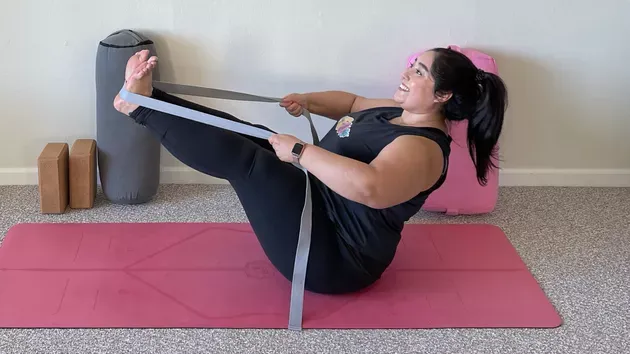 Directions:      Sit on the floor. Place a strap around the arches of your feet and hold strap on each side of your legs.
Squeeze your core to raise your legs off the floor at a 45-degree angle. Bend your knees if needed.
Hold, breathing deeply throughout.  **excellent to build core strength safely with a straight back