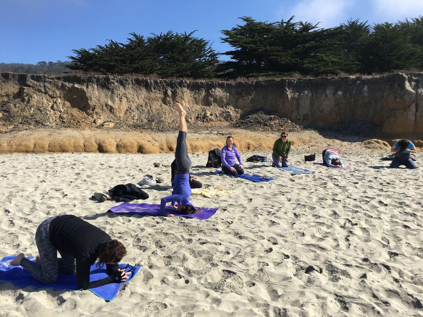 Bree goes toes up, crown down in the sand --- producing a powerful tripod headstand!