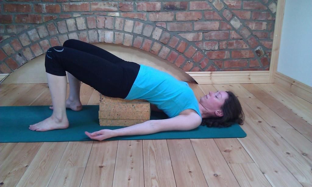 Alyson in supported bridge pose. Supported postures can be quite relaxing, if they are comfy for you.