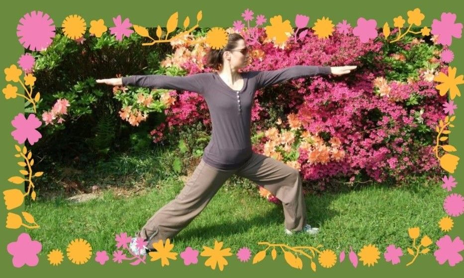Alyson in virabhadrasana (warrior 2) with flowers behind
