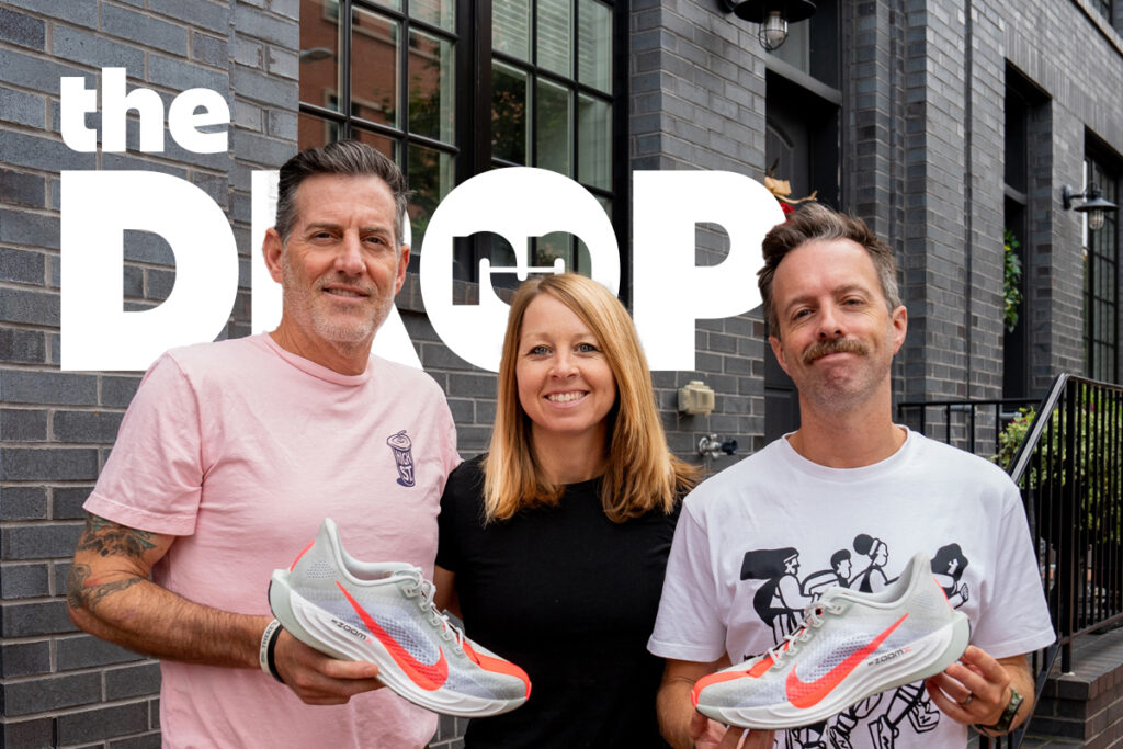 man in pink shirt holding show on left, woman in black shirt in center, man on right in white shirt holding a shoe