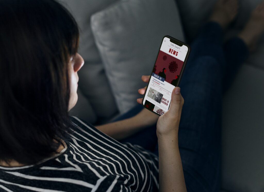 una mujer leyendo noticias en su celular para hacer crecer su marca online