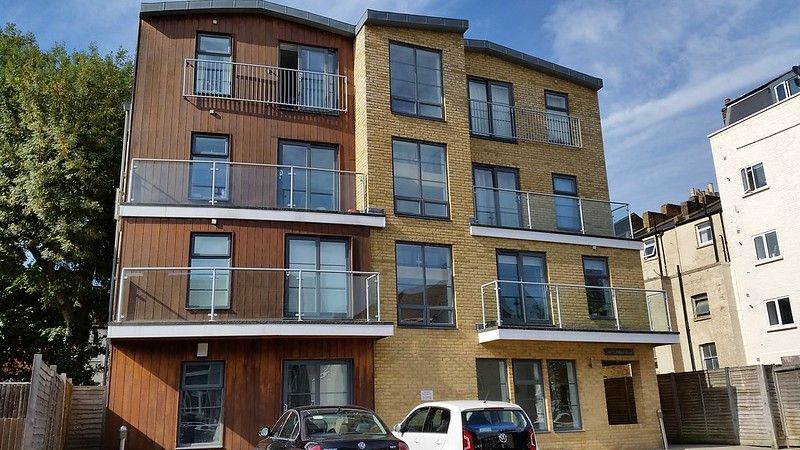 Two cars in front of a three-storey building.jpg