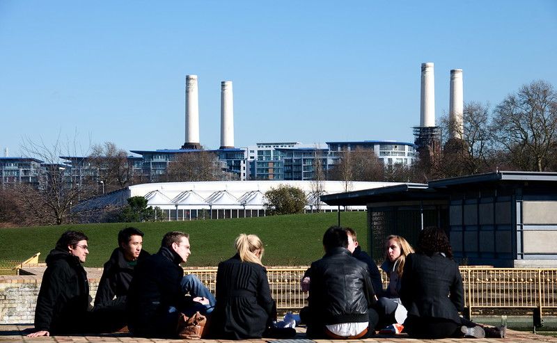 Some people gathering in a park with a power station in the
    background.jpg