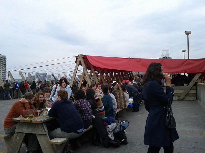 A rooftop cafe with many people sitting along a long table.jpg