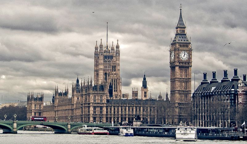 A riverside striking clock alongside a Gothic-style building.jpg