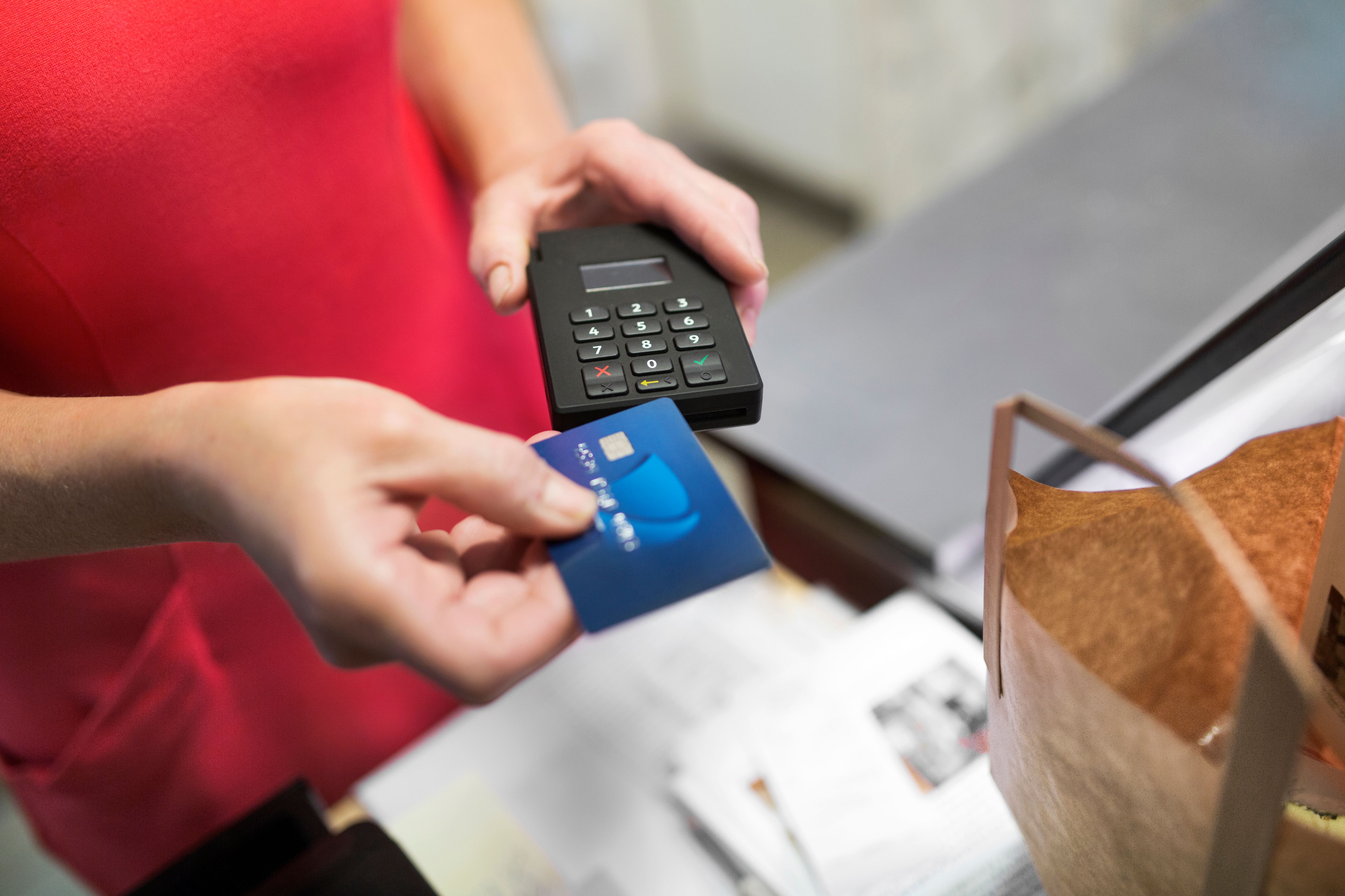 Close-up of a sales clerk putting a credit card into a reader