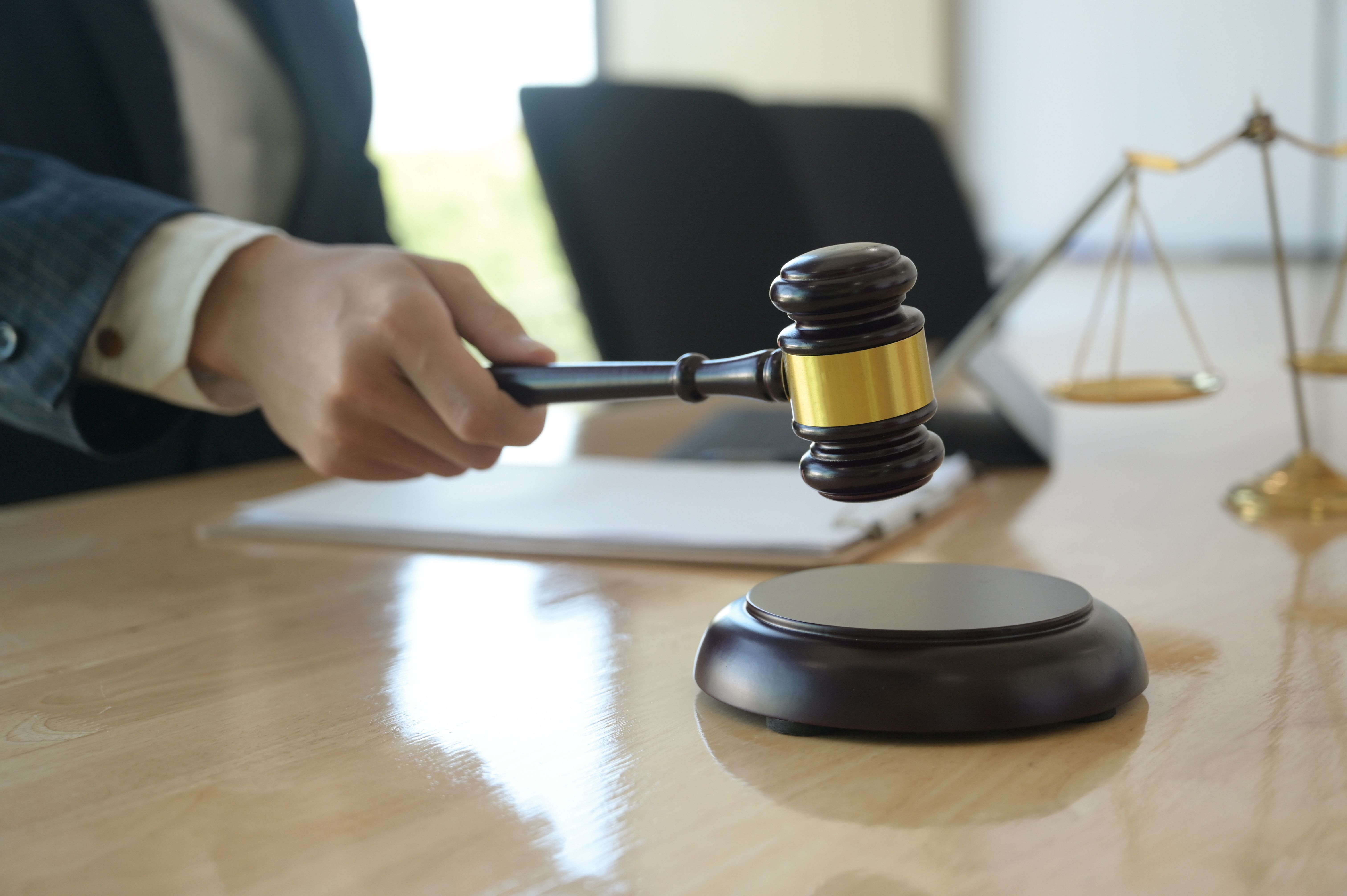 Justice concept, lawyer holding gavel pretending to hit on wooden tray put on desk