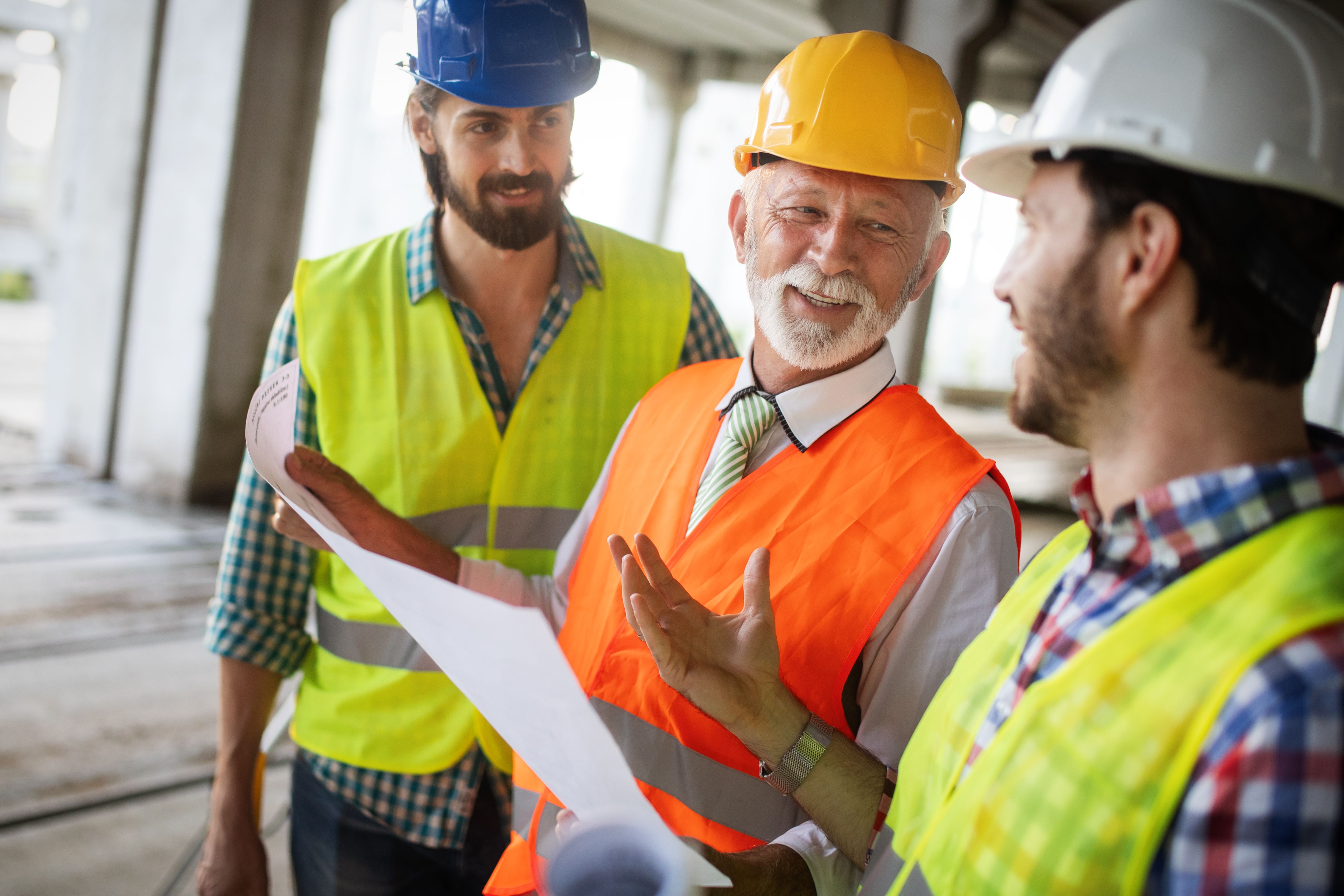 A Build To Rent construction manager discussing with his 2 workers on site delay due to COVID-19.