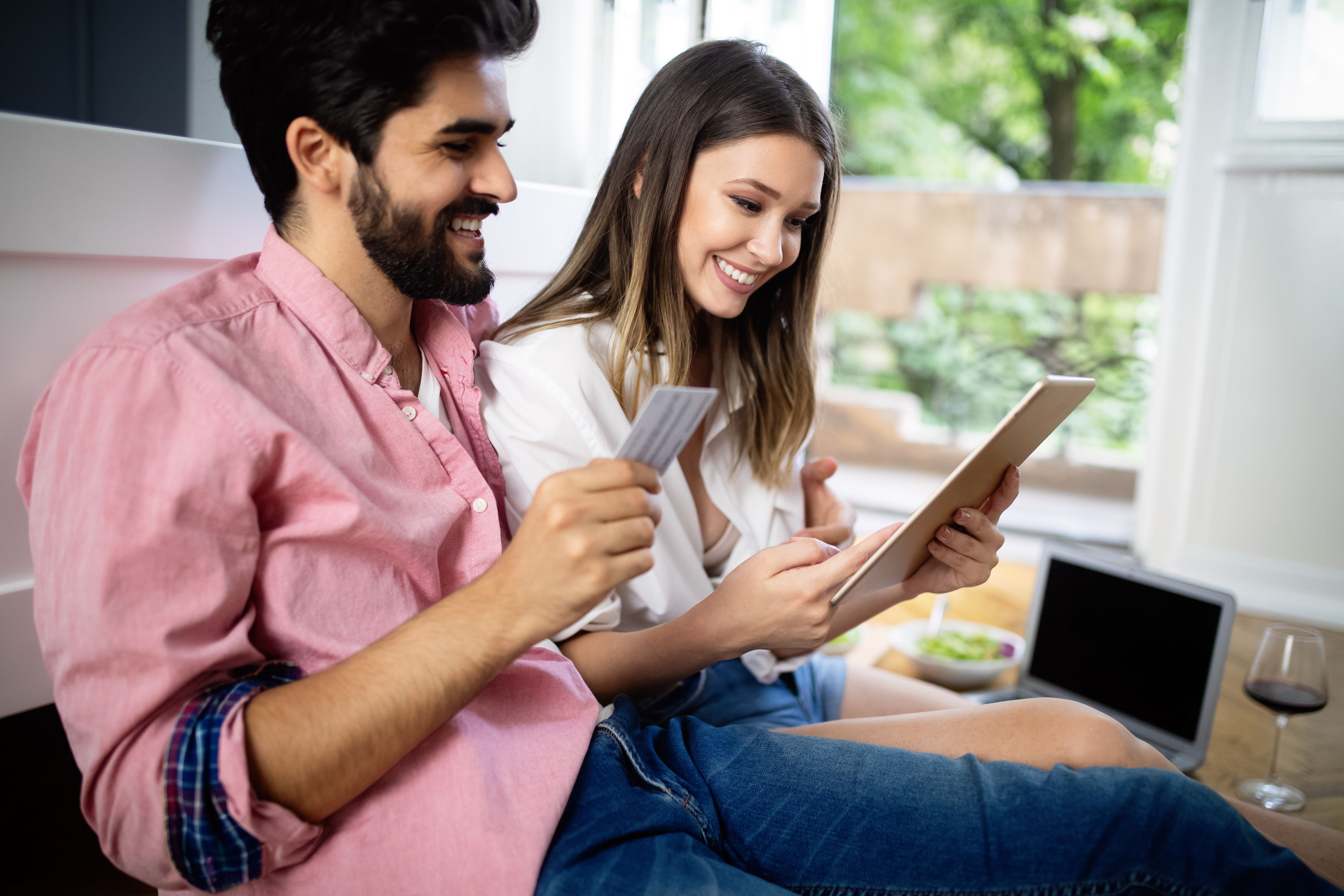 A couple checking their excellent credit history after registering their rental payments with a tracking service.