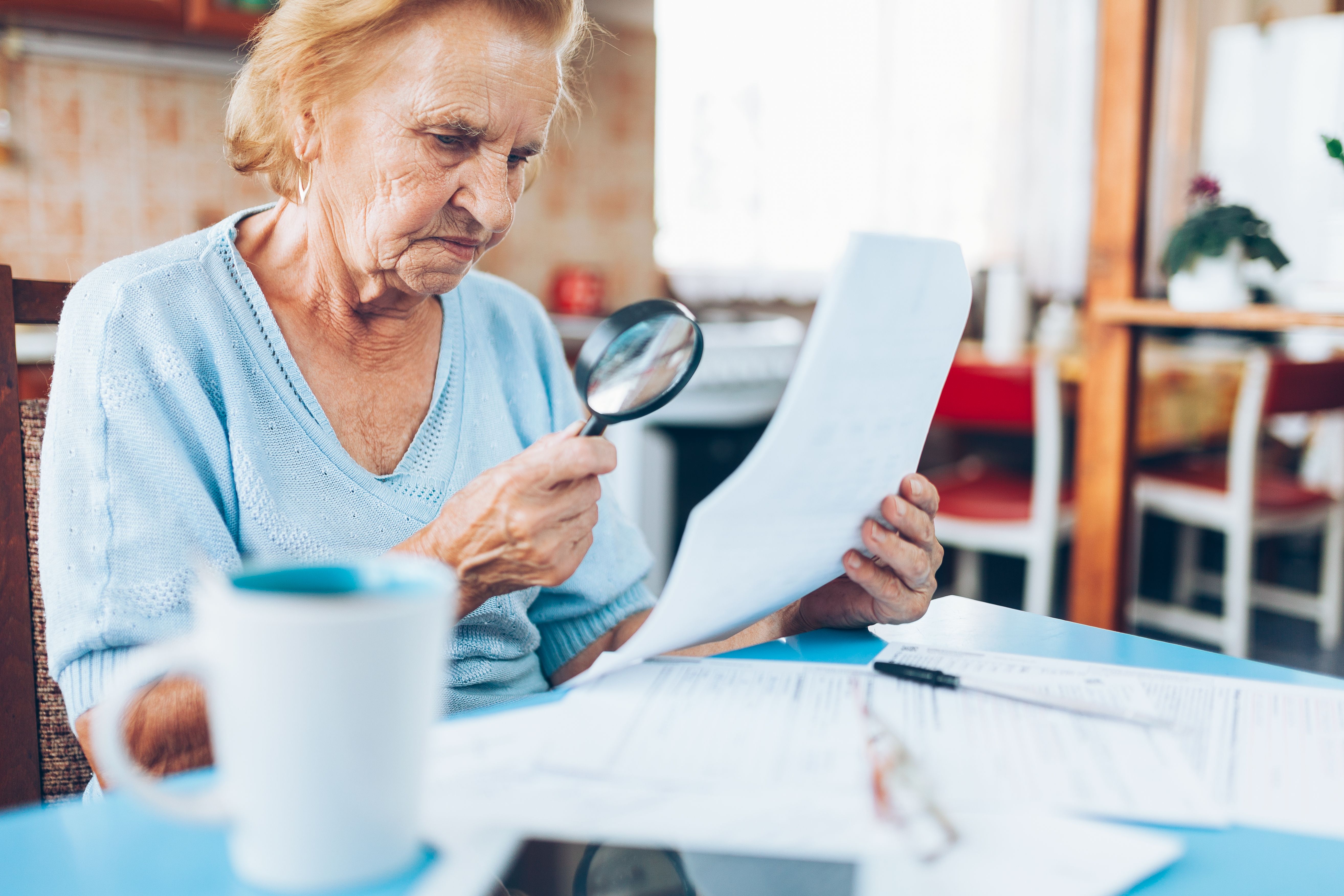 An elderly woman looking at her utility bills