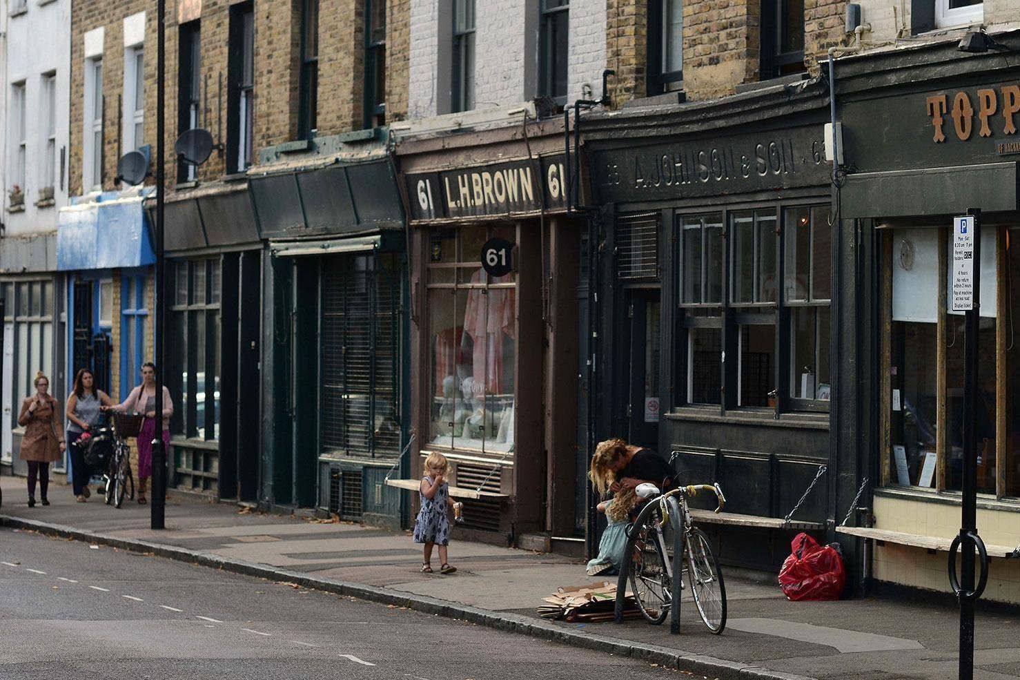 a corner street in Hackney, people walking on pavement