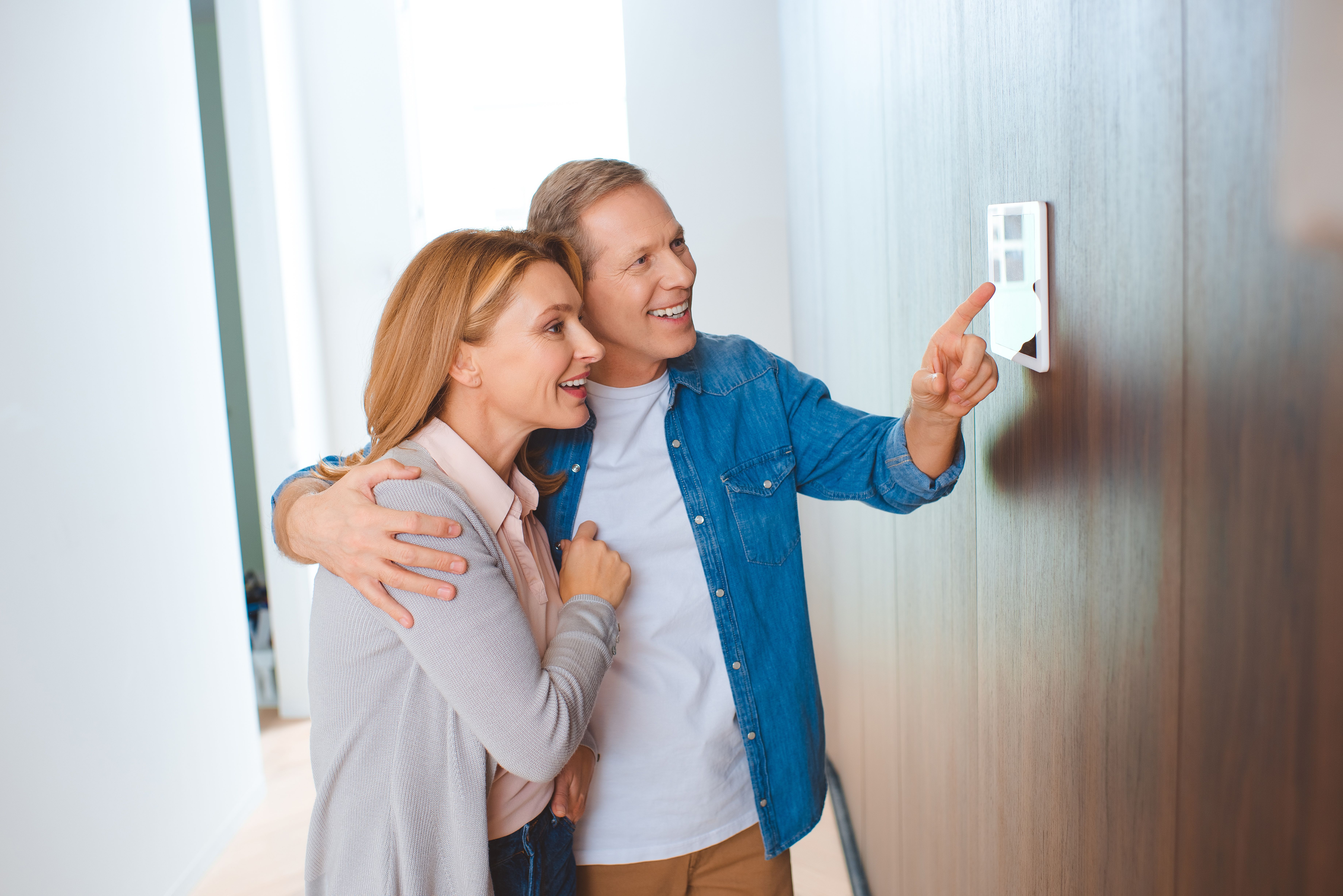 happy man pointing at heating control panel.jpg