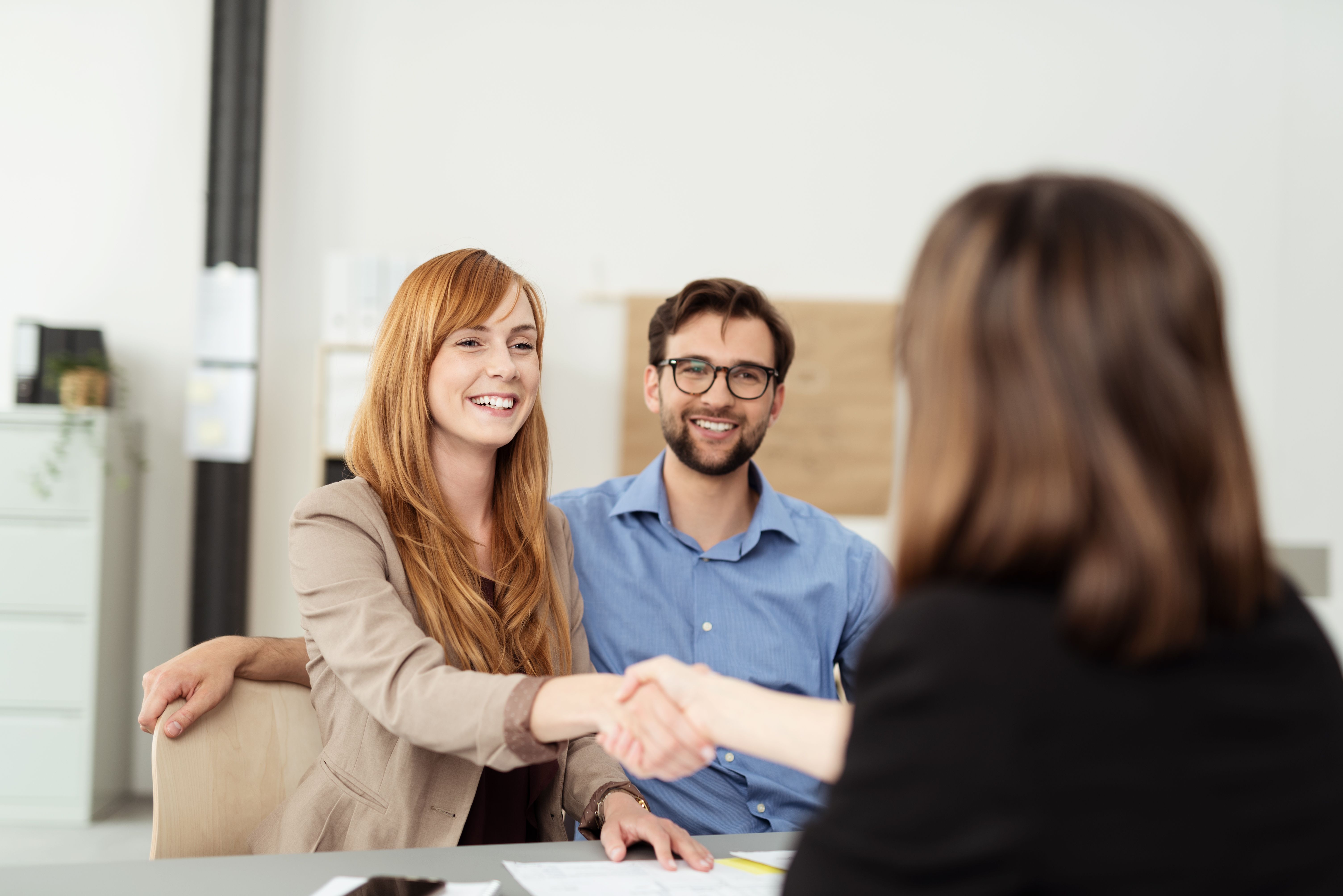 A happy couple shaking hands with a Build To Rent manager as they are welcomed to their new home owned and managed by an institutional landlord.