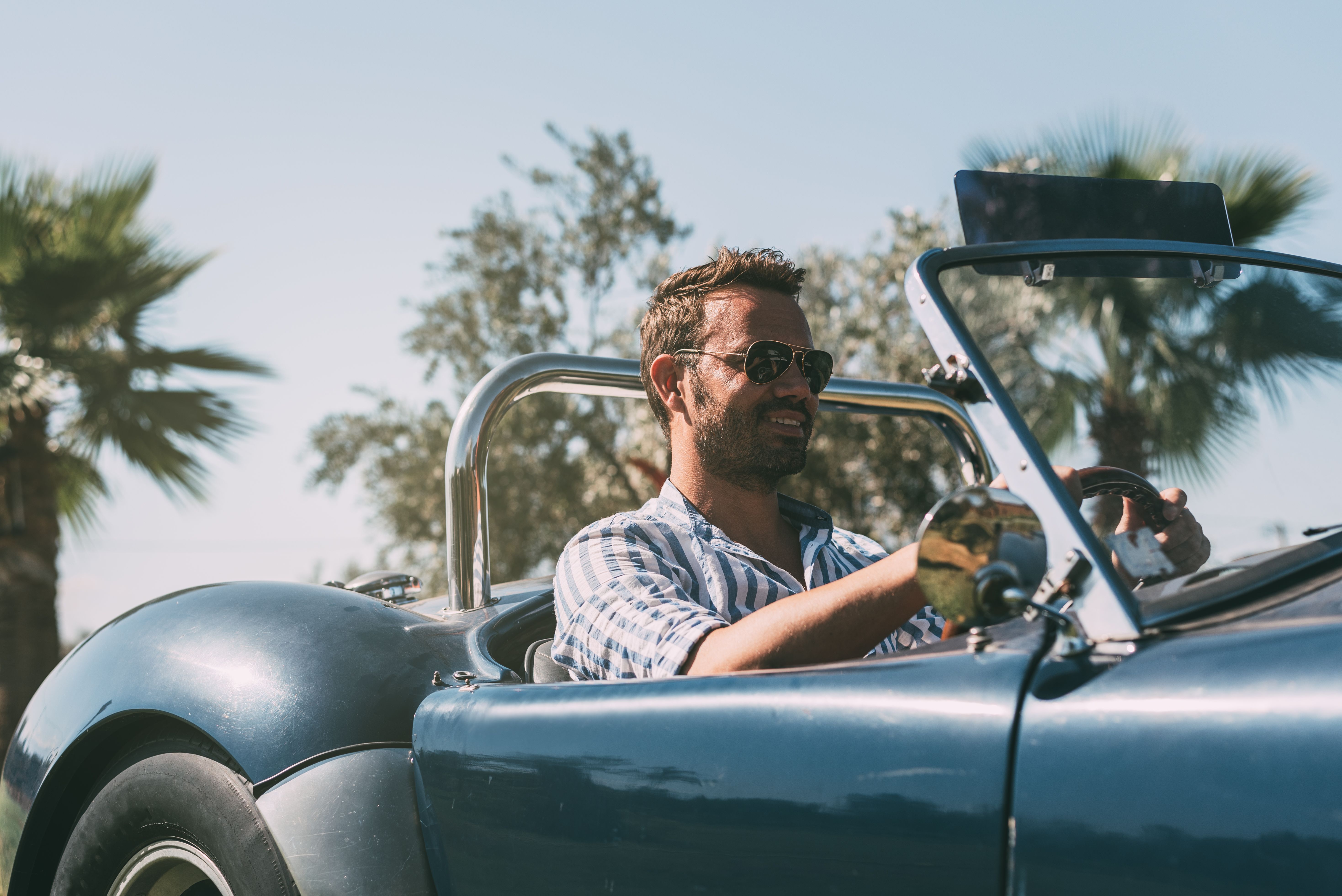 A man driving a convertible car