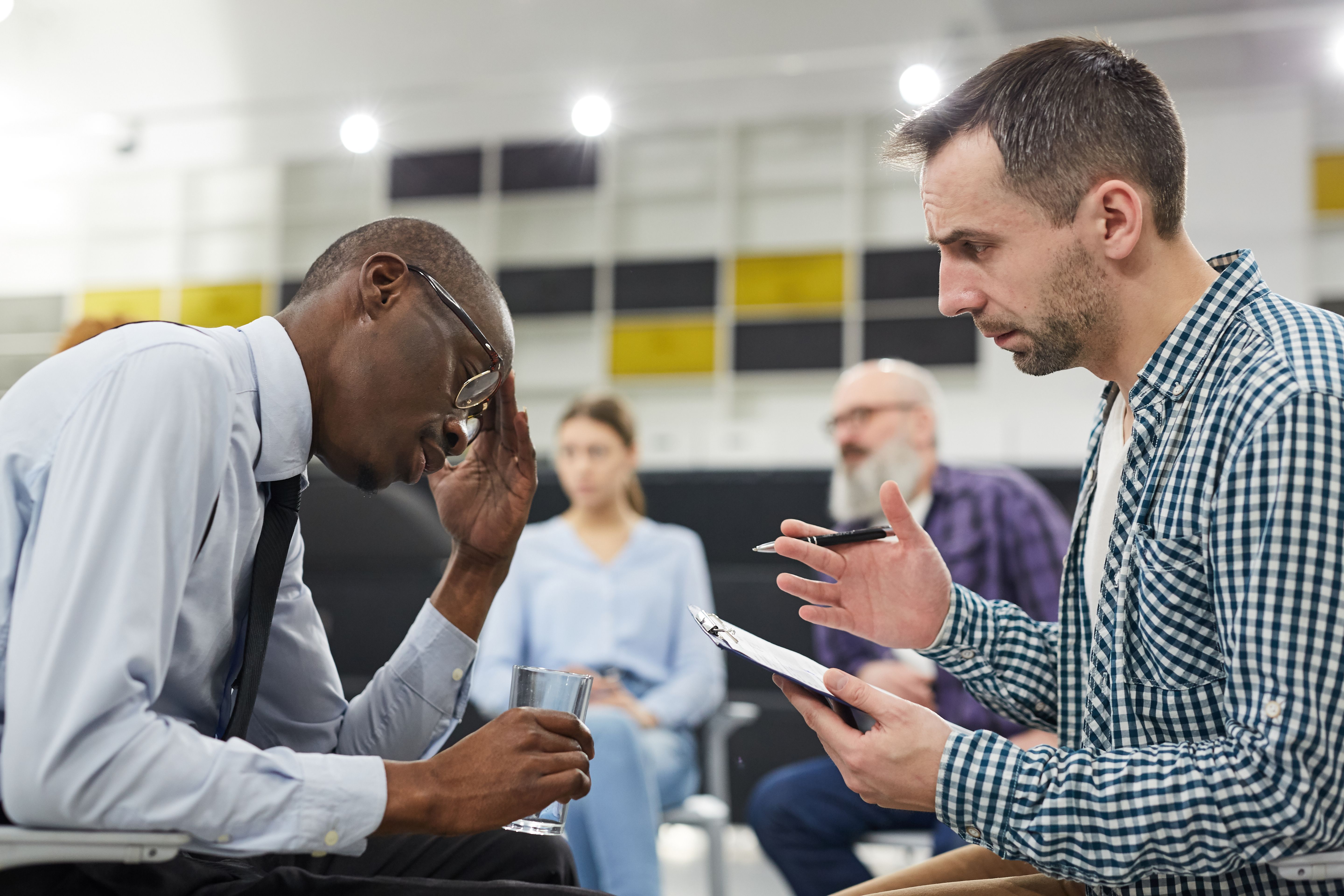 A stressful tenant receiving wellbeing consultation from a mental health expert at his Build To Rent development's social event.