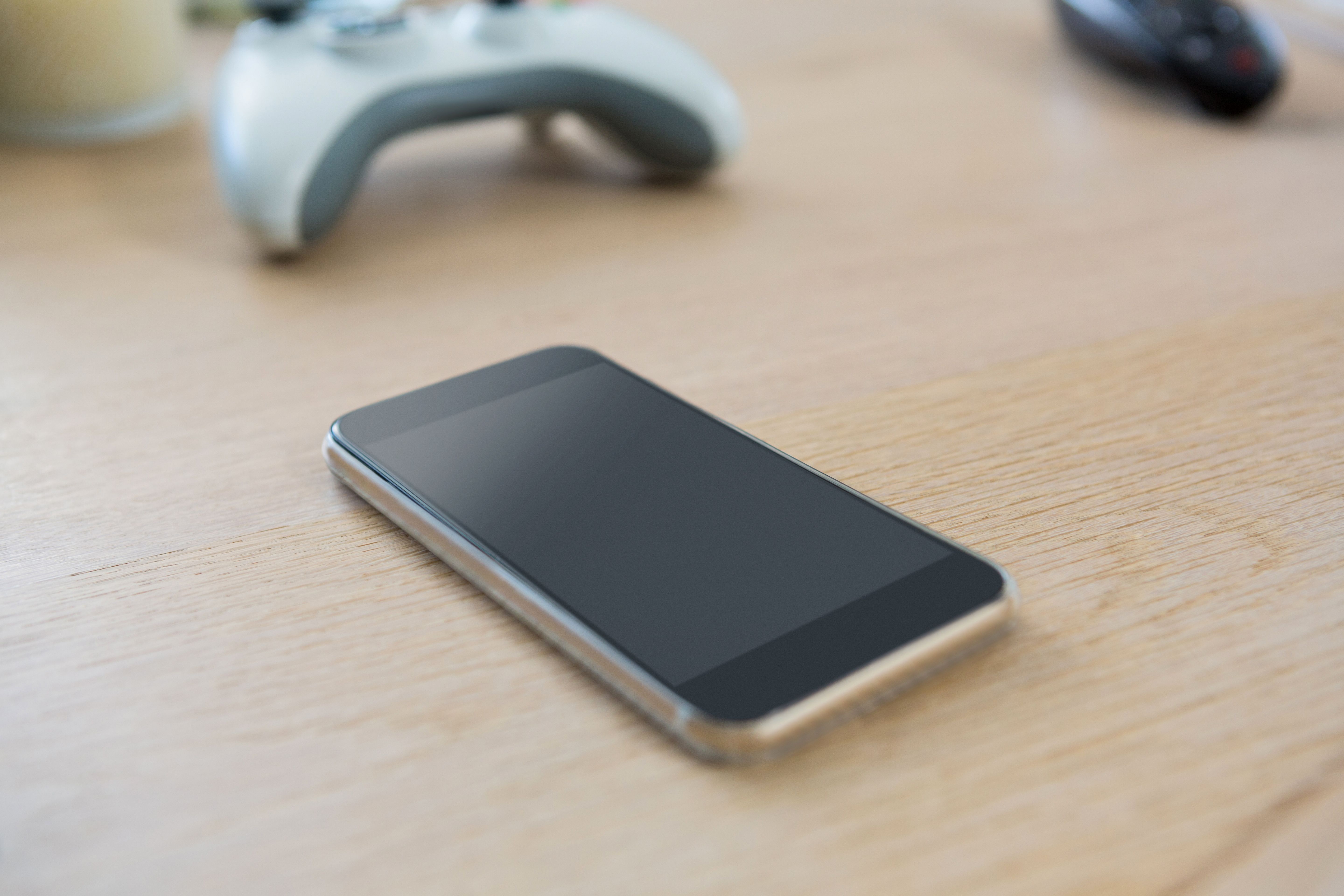 A smartphone and a video game controller on a table