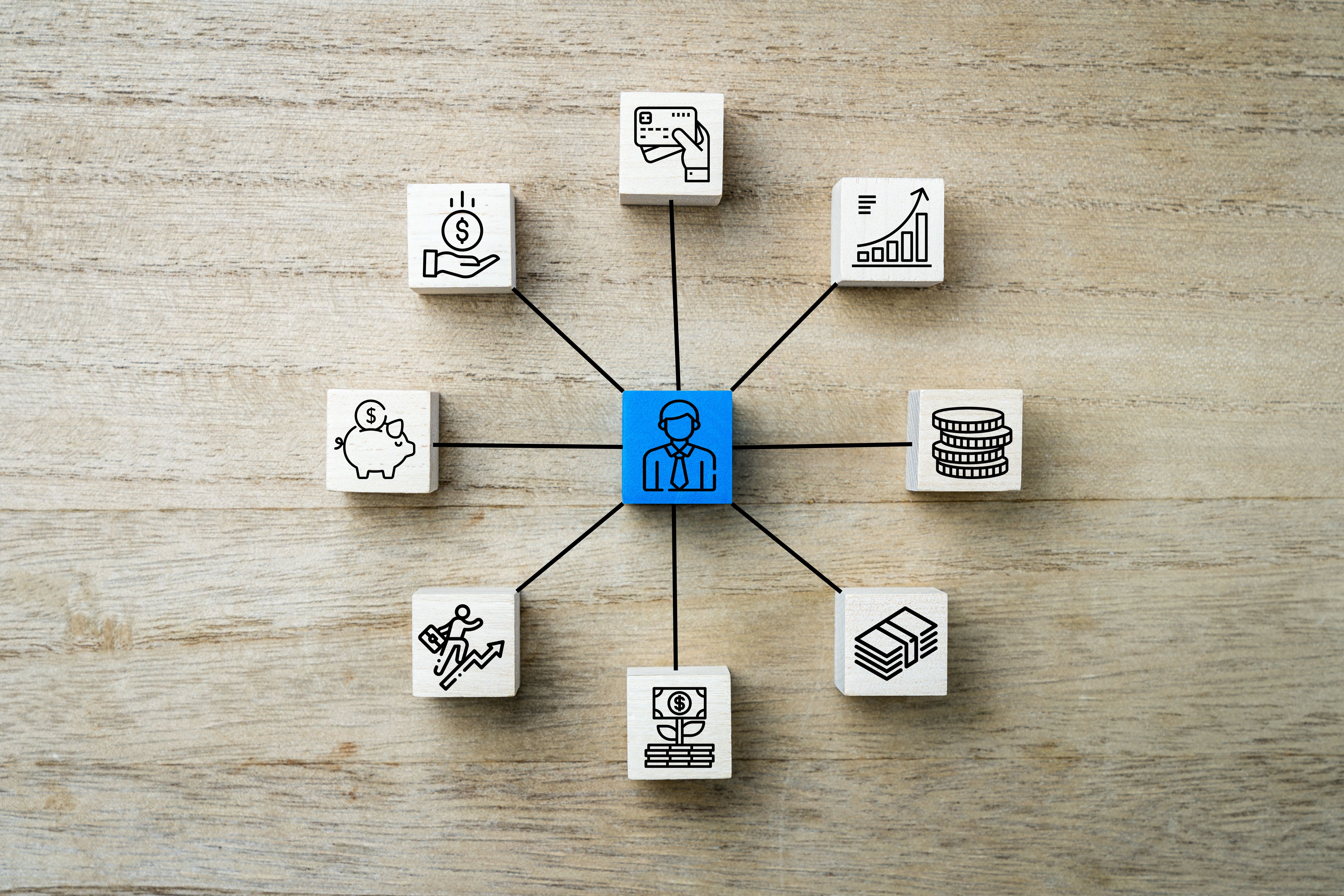 Symbols on wooden square blocks representing incomes and expenses