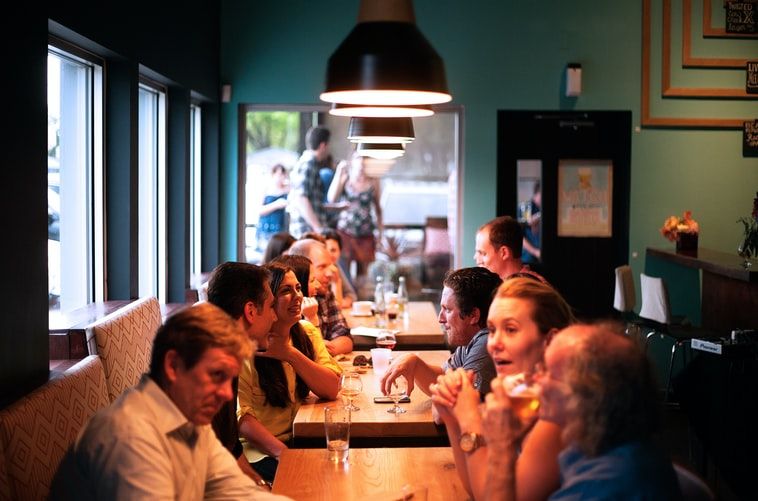 people sitting beside brown wooden table inside a restautant