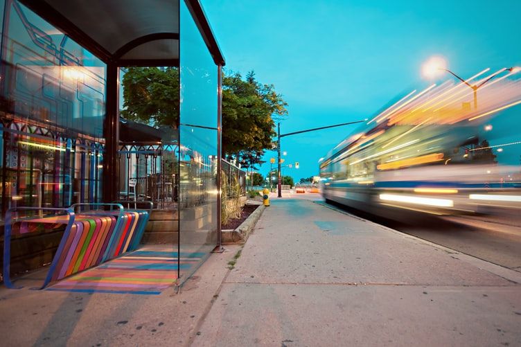 a time-lapse photography of bus passing by on glass wall