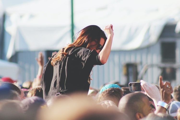 a woman on the top of crowd in a music festival