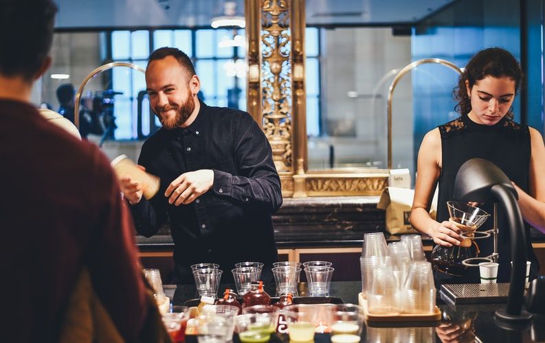 bartenders serving cocktail with a happy face