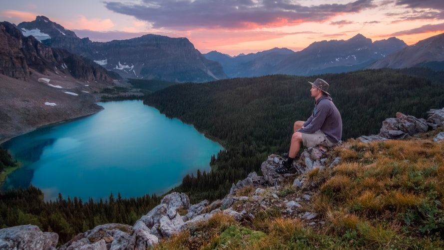 a man sitting on the rock and overlook the beautiful view