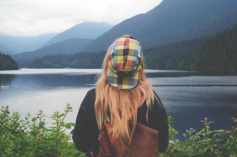 a woman enjoying the beautiful view of a river front 