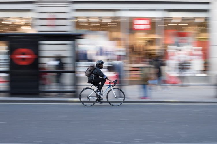 time lapse photo of a person riding on the white bicycle on the street