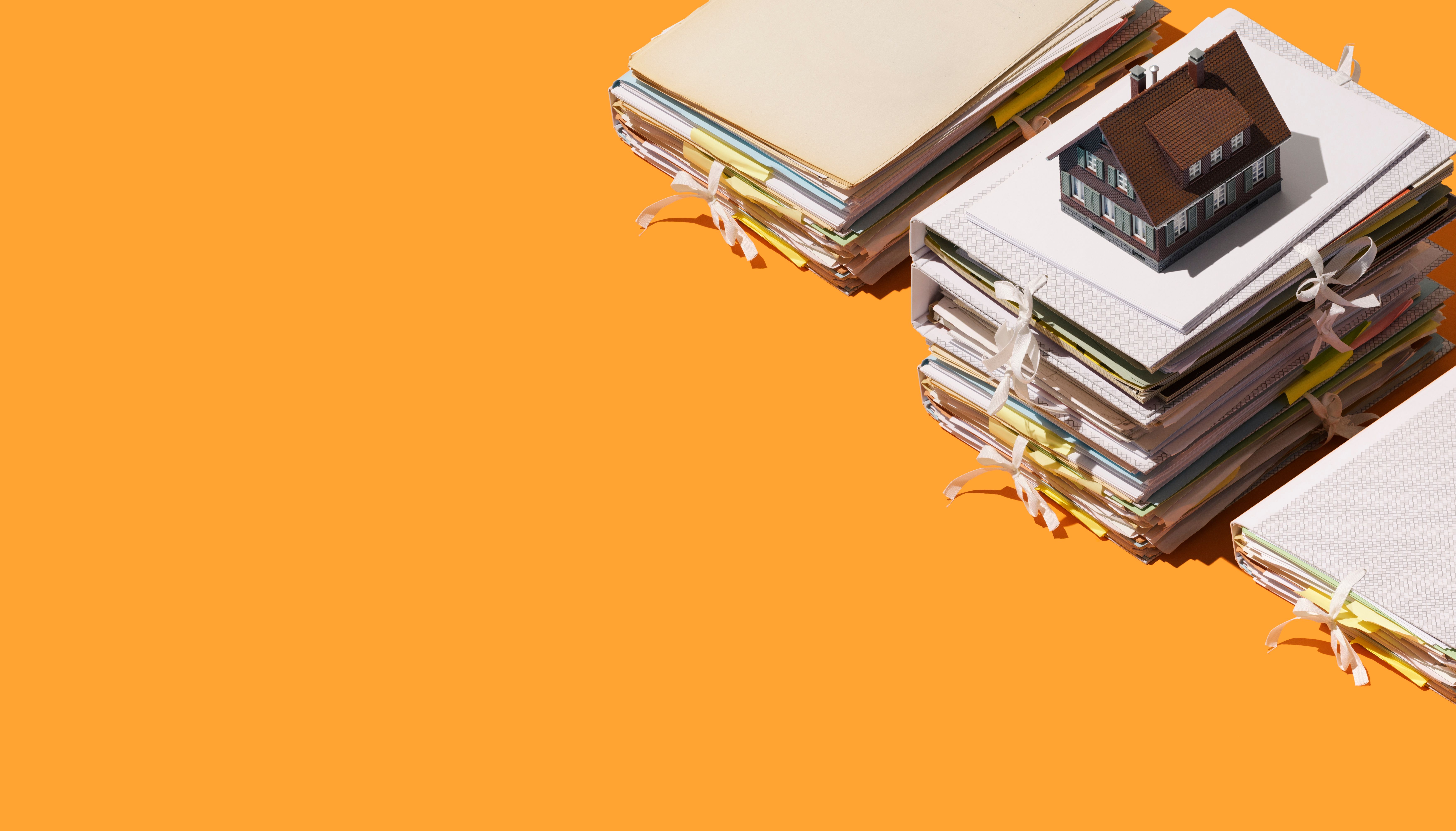 A model house and piles of documents and folders