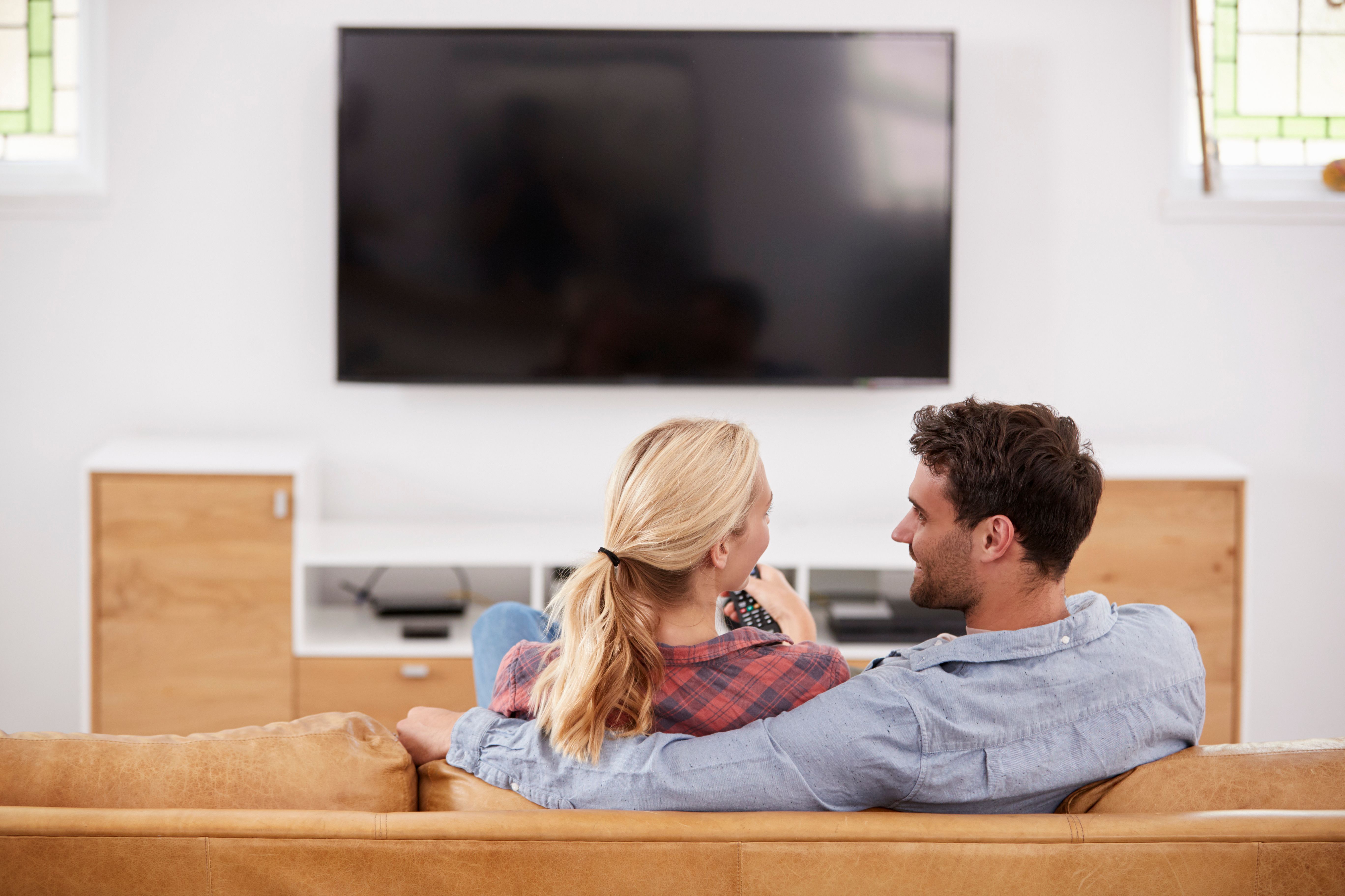 Rear view of a couple watching television together