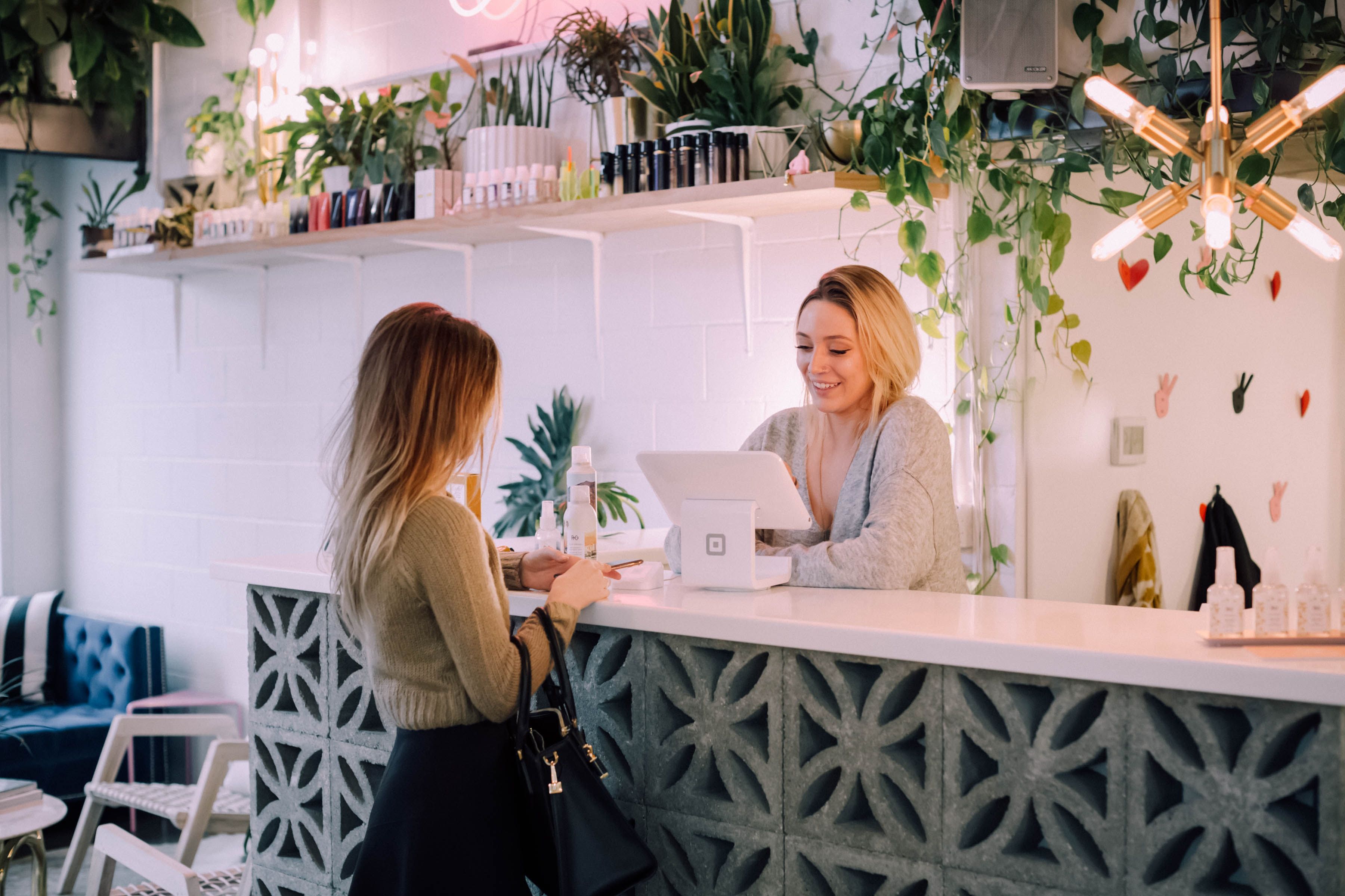 A happy receptionist helps a new tenant check in to her new plant-friendly Build To Rent property