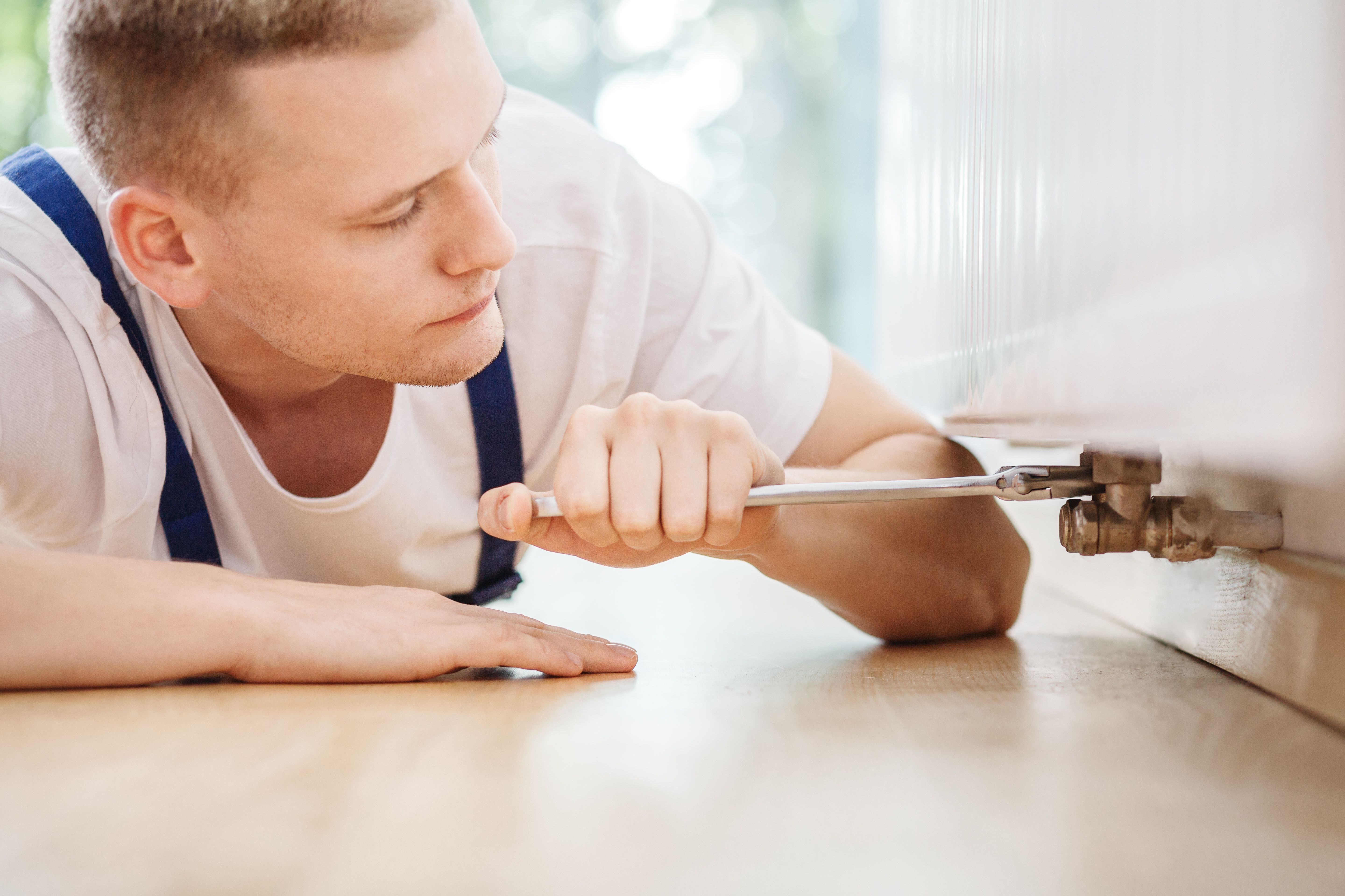 A technician specialist using tools to repair radiator fault