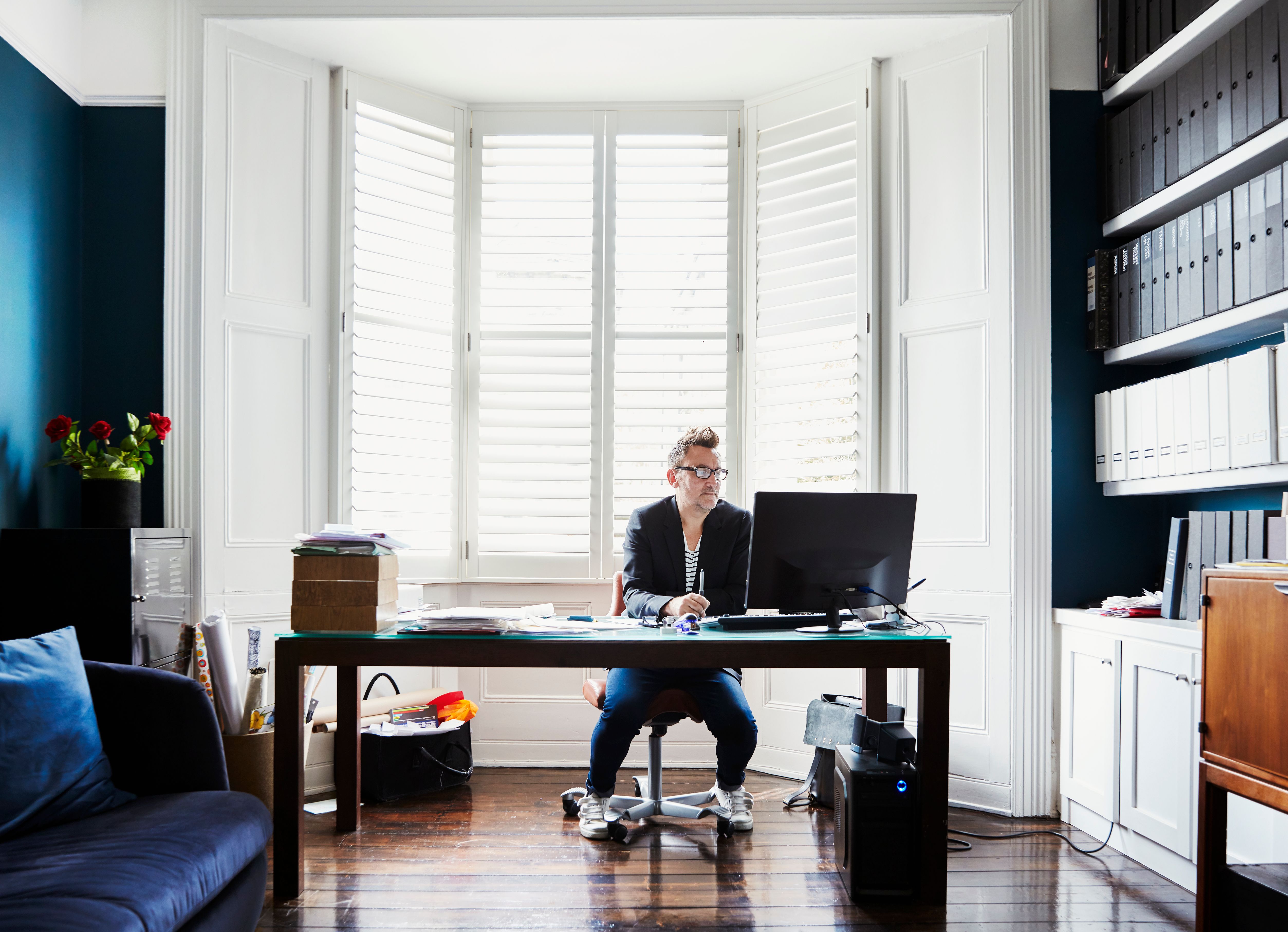 A male tenant sitting at his home office researching about tenancy options available at a Build To Rent property.