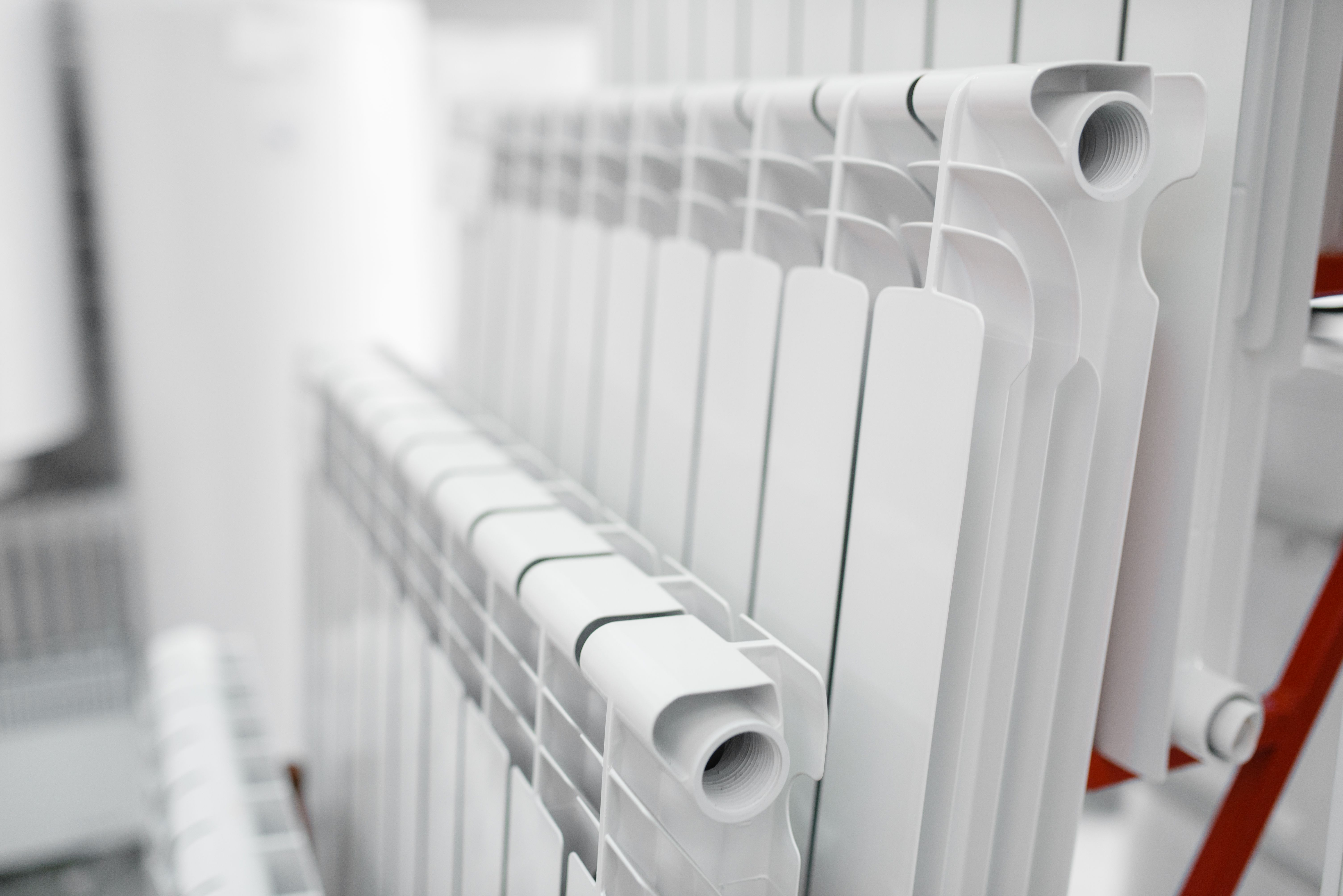 A white radiator installed in a home against a blurred background.jpg